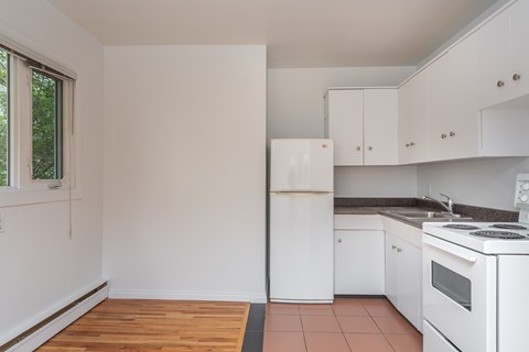 A kitchen with white appliances and cabinets.