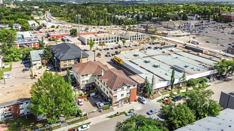A parking lot is surrounded by buildings in the image.