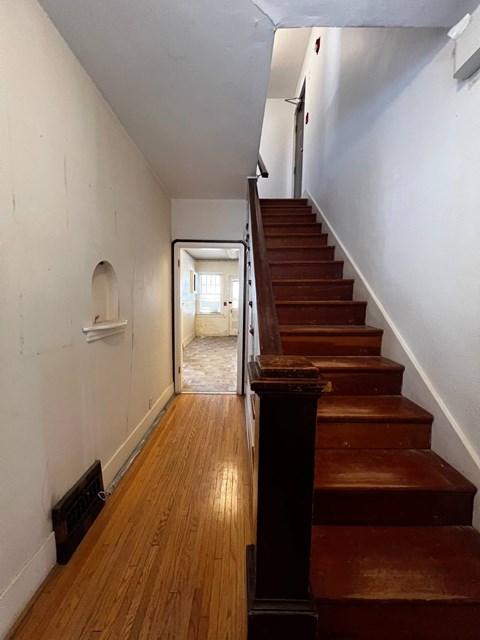 A room with a white floor and a brown wooden wall.