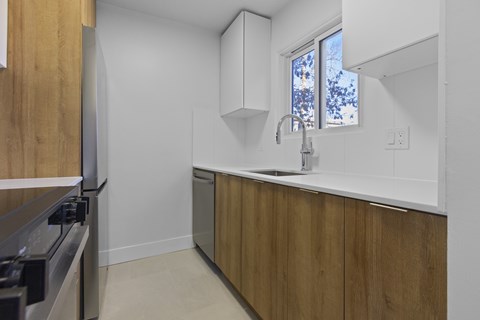 A kitchen with wooden cabinets and a window.