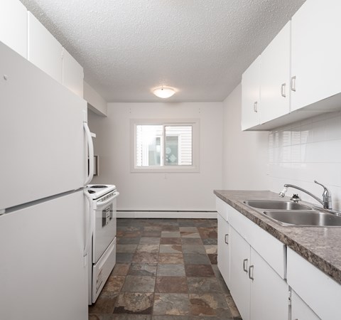A kitchen with white appliances and cabinets.