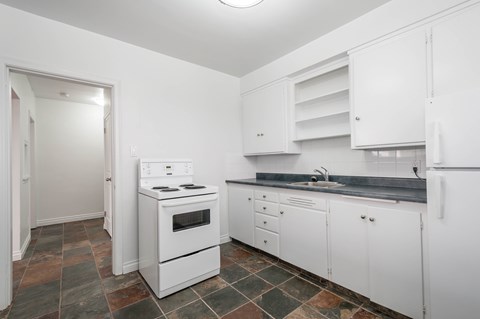 A kitchen with white appliances and cabinets.