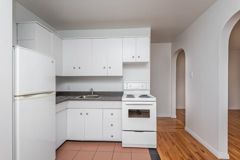 A kitchen with white appliances and cabinets.