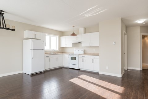 A kitchen with white appliances and cabinets.