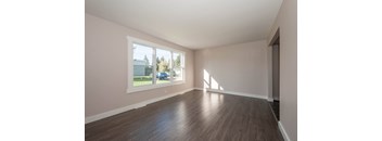 A room with wooden floors and a large window.