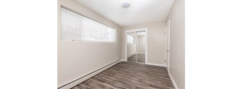 A room with a wooden floor and a sliding glass door.