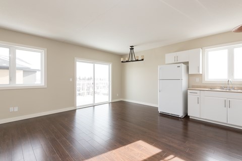 A kitchen with white appliances and wooden floors.