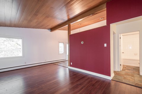 A room with wooden floors and a red wall.