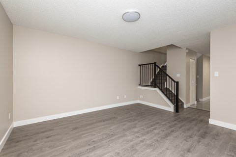 A spacious room with a staircase leading to the upper floor.