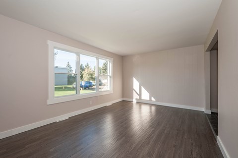 A room with wooden floors and a large window.