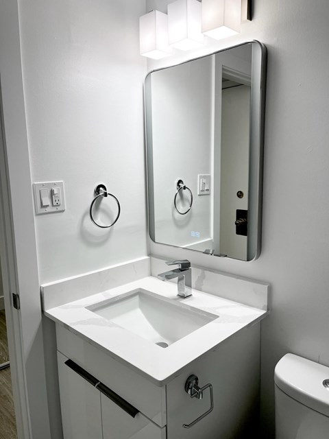 A white bathroom sink with a mirror above it.