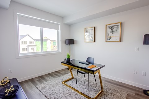 A black and gold table with a plant on it in a room with white walls.