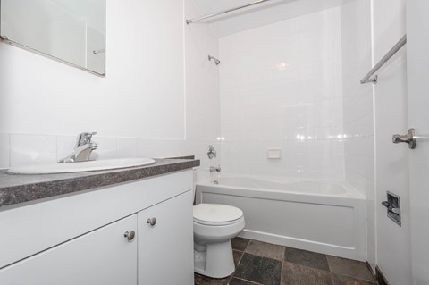 A white bathroom with a sink, toilet, and bathtub.
