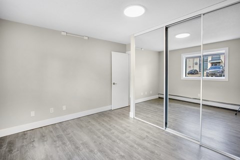 A room with a white door and a picture on the wall.
