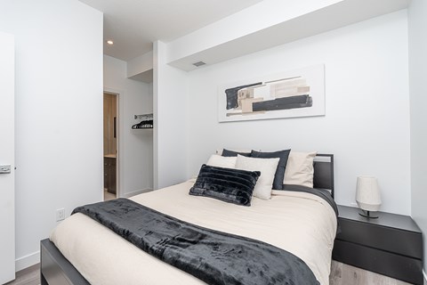 A bedroom with a bed, nightstand, and lamp.