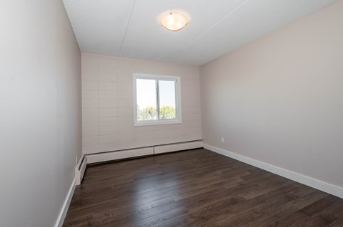 A room with wooden flooring and a window.