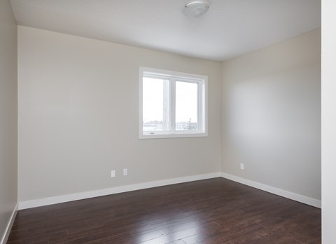 A room with a window and wooden floors.