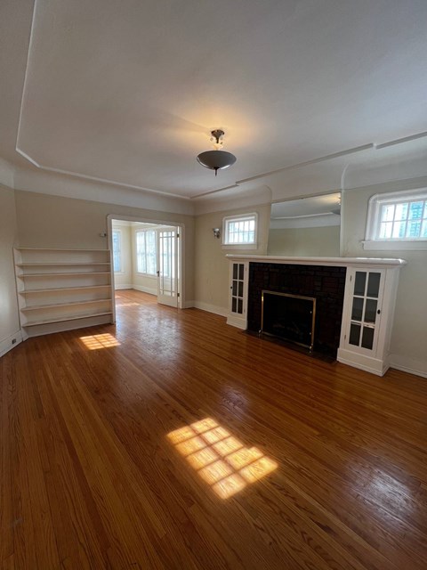 A room with a fireplace and a wooden floor.