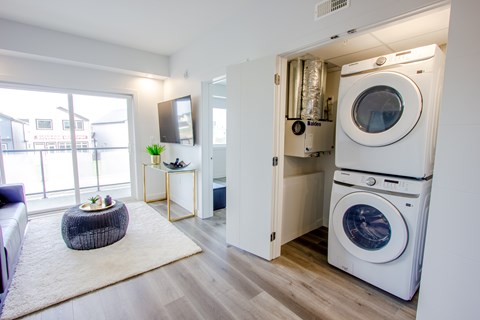 A modern laundry room with a washer and dryer stacked on top of each other.