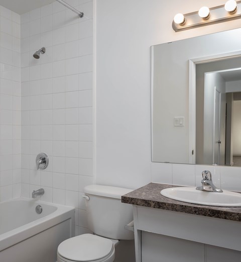 A white bathroom with a sink, toilet, and bathtub.