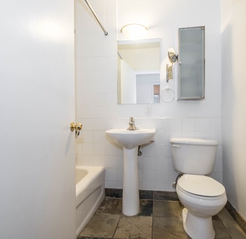 A white toilet sits next to a sink in a bathroom.