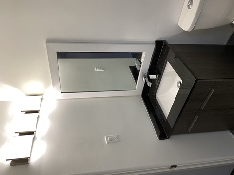 A white ceiling with a light fixture and a small square light on the left side.