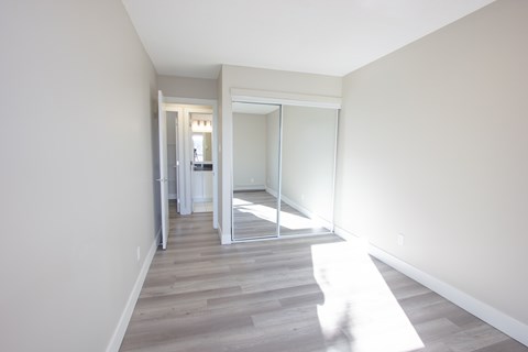 A hallway with a sliding glass door leading to a bedroom.