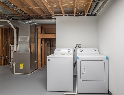 Two large white appliances in a room under construction.