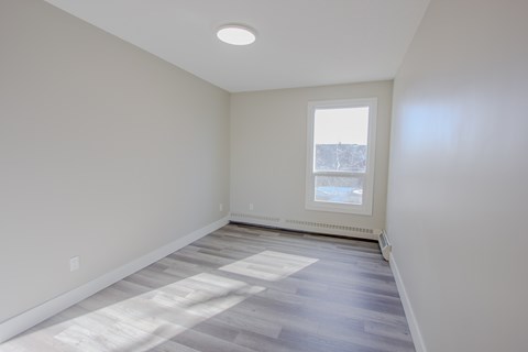 A room with a window and a radiator on the wall.