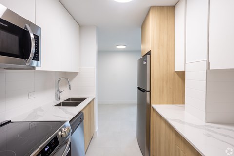 A modern kitchen with a stainless steel oven and microwave.