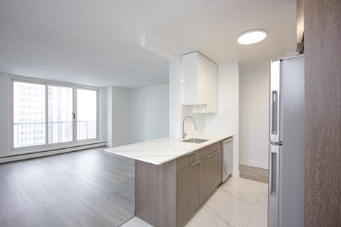 A kitchen with a white counter top and wooden cabinets.