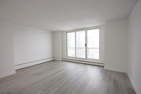 A room with a window and wooden flooring.