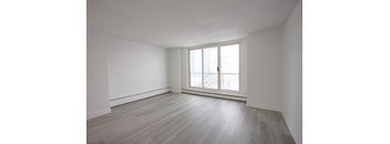 A room with a window and wooden flooring.