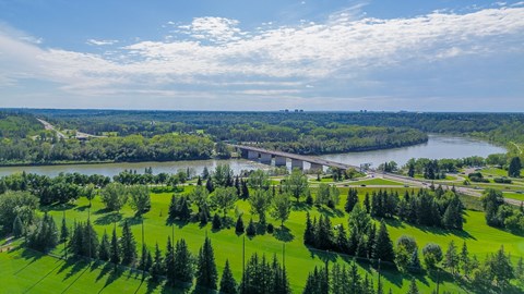 A bridge spans a river in a lush green landscape.