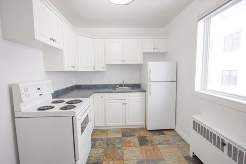 A kitchen with white appliances and cabinets.