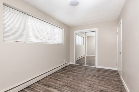 A room with a sliding glass door and a wooden floor.