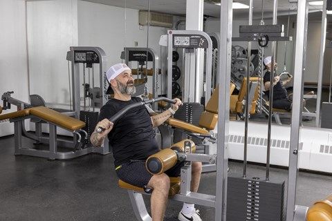 A man is working out in a gym using a machine.