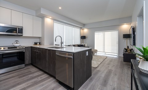 A modern kitchen with a large island and stainless steel appliances.