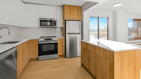 A modern kitchen with wooden cabinets and stainless steel appliances.
