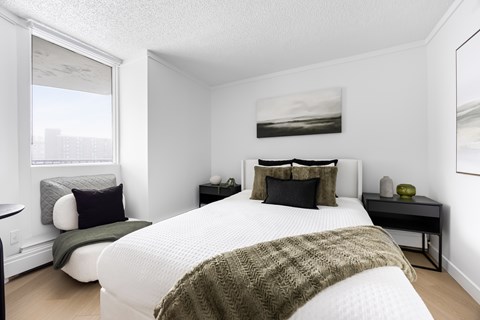 A bedroom with a large bed and a green blanket.