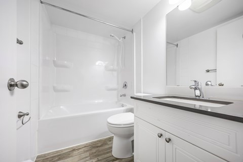 A white bathroom with a toilet, sink, and bathtub.