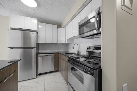 A modern kitchen with stainless steel appliances and white cabinets.