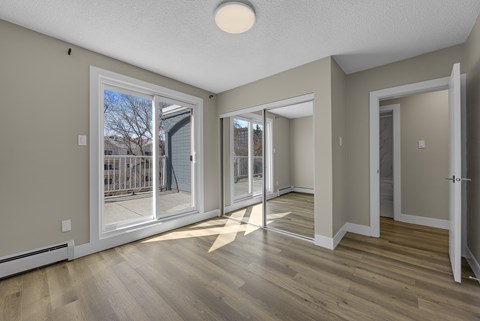 A room with a sliding glass door leading to a balcony.