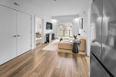 A modern living room with a wooden floor and a large window.
