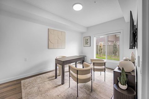 A modern dining room with a table and chairs.