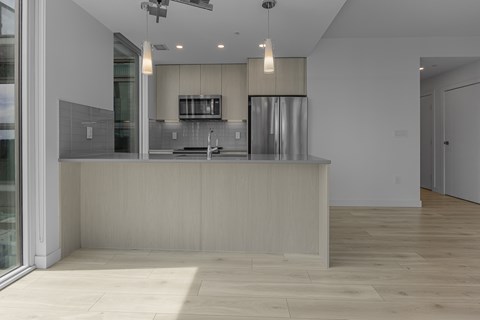 A modern kitchen with a wooden counter and stainless steel appliances.