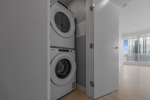 A modern laundry room with a washer and dryer built into the wall.