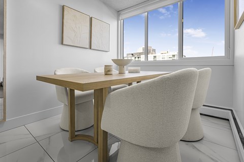A dining room with a table and chairs.
