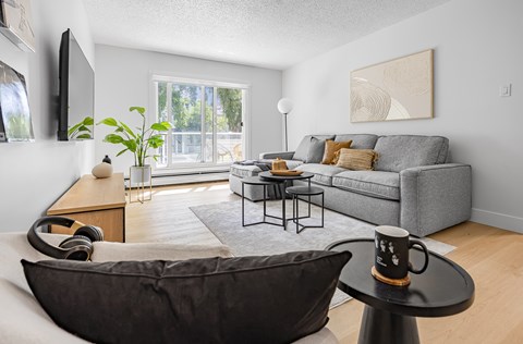 A living room with a grey couch, a black armchair, and a coffee table.