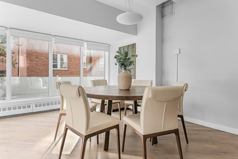 A dining room with a table and chairs.